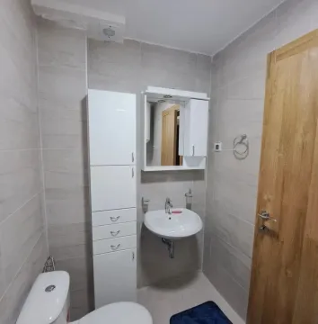 Manje kupatilo sa bijelim elementima, umivaonikom i wc šoljom. - image 6