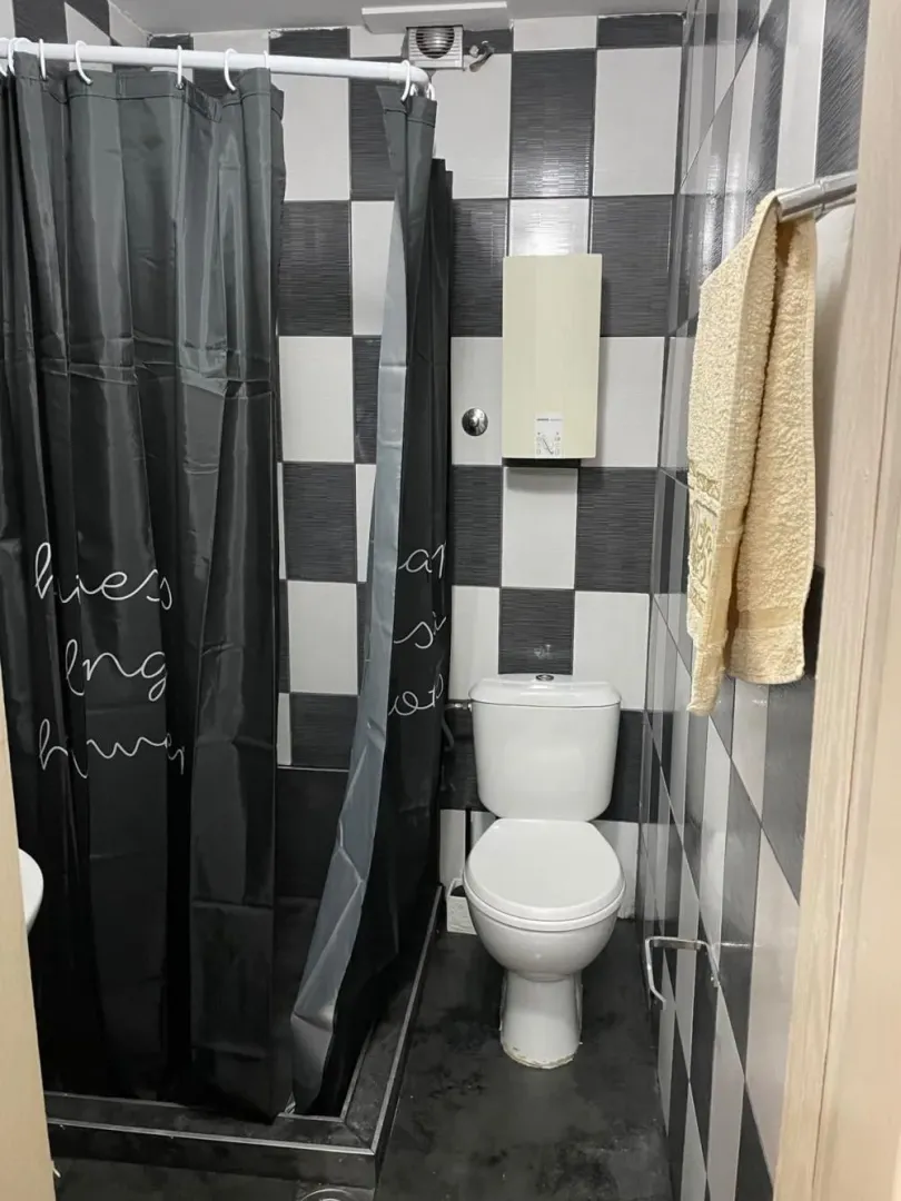 Bathroom with a shower cabin and black and white tiles.