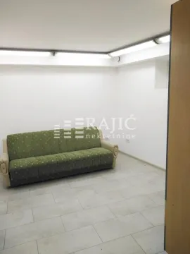 Living room with a green sofa and light tile flooring. - image 2
