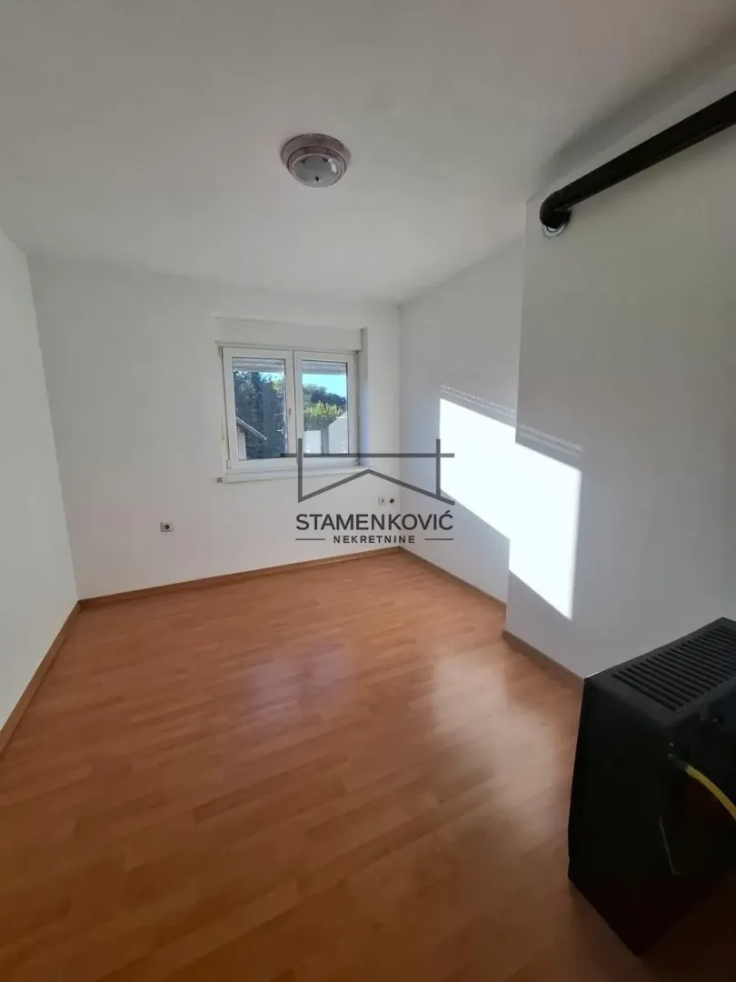 Empty room with laminate flooring and white walls.