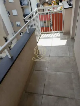 Manji popločani balkon sa belom ogradom i pogledom na okolne zgrade. - image 7