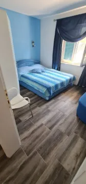 Namještena spavaća soba sa bračnim krevetom i plavim detaljima. - image 11