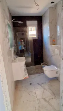 Manje kupatilo sa svijetlim pločicama i tuš kabinom. - image 7
