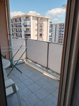 Manji popločani balkon sa ogradom i pogledom na okolne zgrade. - image 5