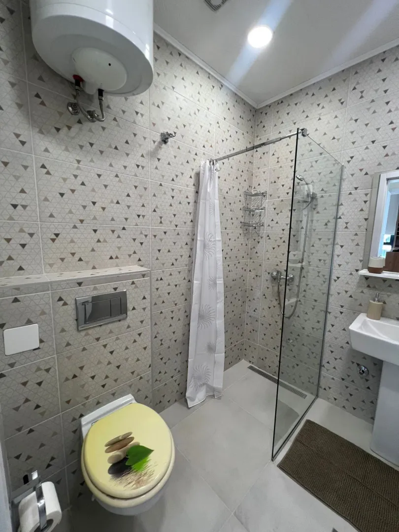 Kupatilo sa tuš kabinom, WC šoljom i umivaonikom.