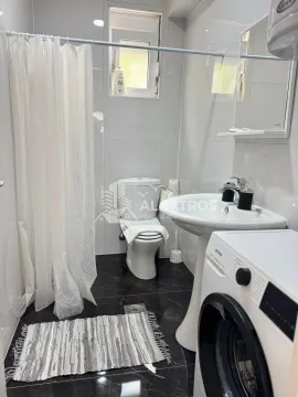 Kupatilo opremljeno sanitarijama, tuš kabinom sa zavjesom i veš mašinom. - image 4