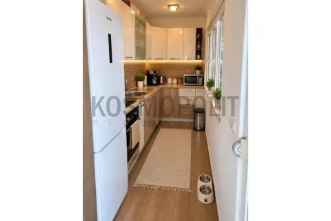 Small narrow kitchen with a white refrigerator and wooden cabinetry. - image 5