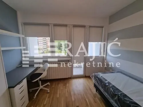 Furnished bedroom with a bed, desk, and access to the terrace.