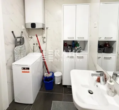 Small bathroom with a washing machine, sink, and white cabinet. - image 11