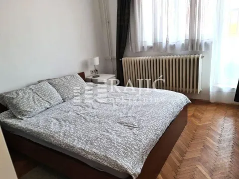 Spavaća soba sa bračnim krevetom, parketom i radijatorom. - image 9
