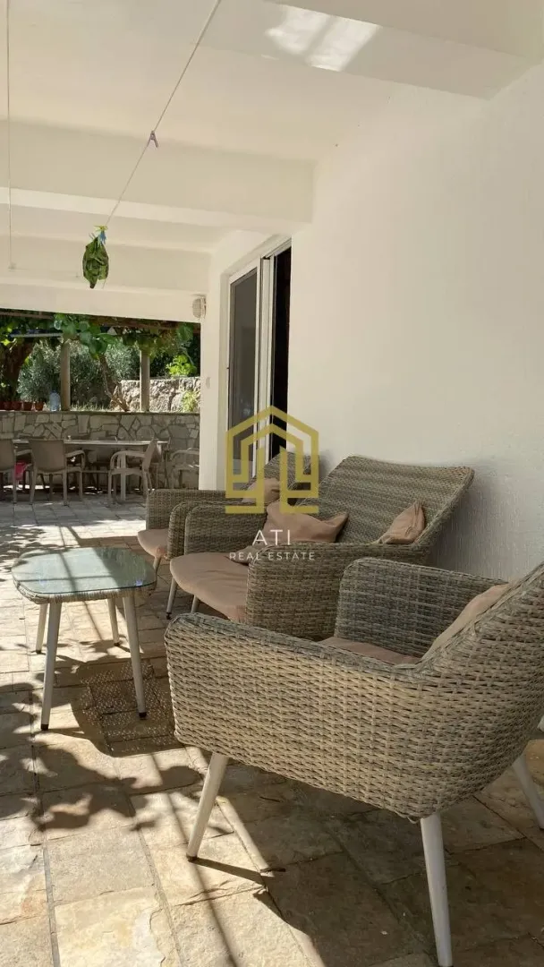 Covered terrace with seating furniture and a view of the yard.
