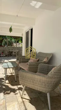 Covered terrace with seating furniture and a view of the yard. - image 19
