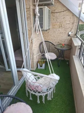 Manji namešteni balkon sa visećom foteljom i stolom sa stolicama. - image 2