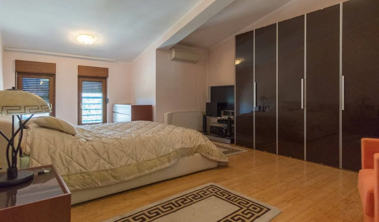 Prostrana spavaća soba sa bračnim krevetom i velikim ugradnim garderoberom.