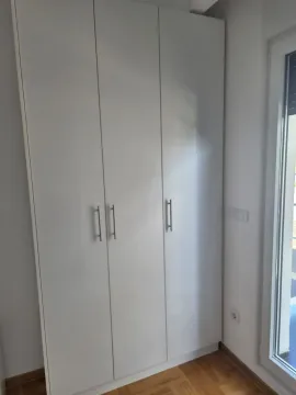 Beli ugradni garderober u sobi sa parketom i izlazom na terasu. - image 10