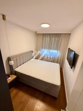 Nameštena spavaća soba sa velikim bračnim krevetom i televizorom na zidu. - image 6