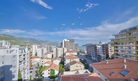Pogled sa prozora na okolne zgrade, grad i brda u pozadini. - image 3