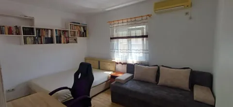 Smaller bedroom with a bed, sofa, desk, and wall bookshelf. - image 15