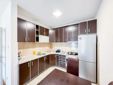 Equipped kitchen with dark wooden cabinets and a dining table. - image 3