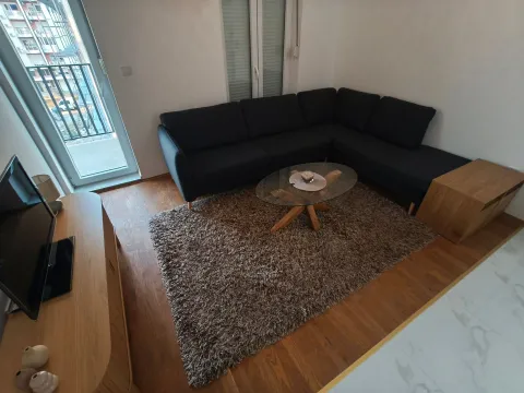 Living room with sofa, coffee table, and television. - image 5