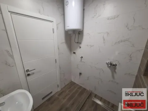 Pogled na kupatilo obloženo keramičkim pločicama sa ugrađenim bojlerom i sanitarijama. - image 4