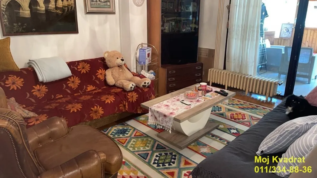 Dnevna soba sa garniturom, foteljom i stočićem.