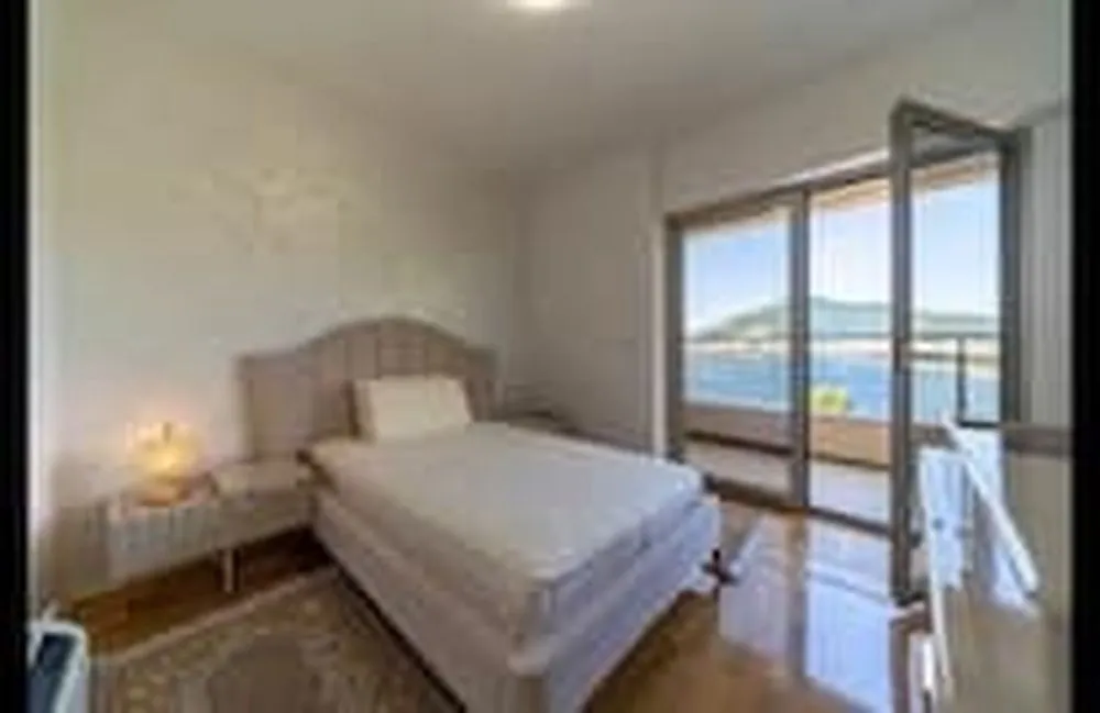 Bright bedroom with a double bed and access to a terrace with sea views.