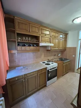 Traditional kitchen with wooden cabinetry, stove, and sink. - image 3