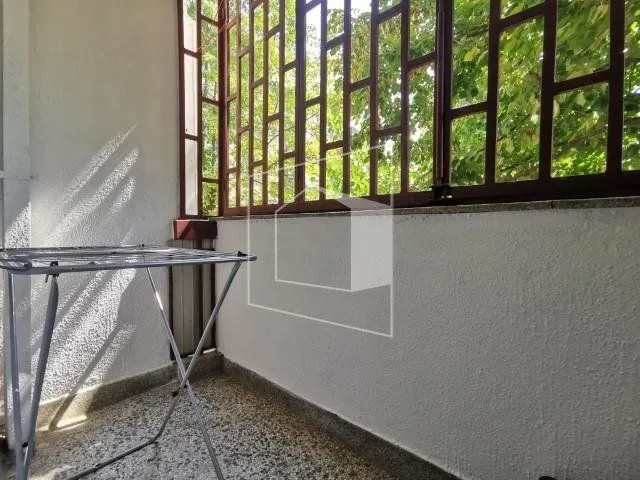 Natkrivena terasa sa metalnom ogradom i sušilicom za veš.