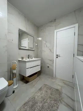 Moderne kupatilo obloženo keramičkim pločicama sa umivaonikom i ogledalom. - image 4