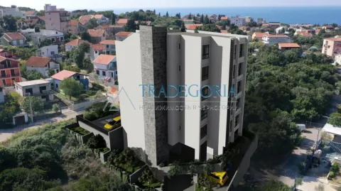 Pogled iz vazduha na eksterijer stambene zgrade i okolno naselje sa pogledom na more. - image 2