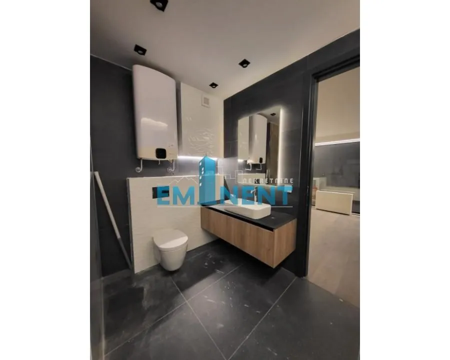 Modern bathroom equipped with a walk-in shower, wall-hung vanity, and toilet.