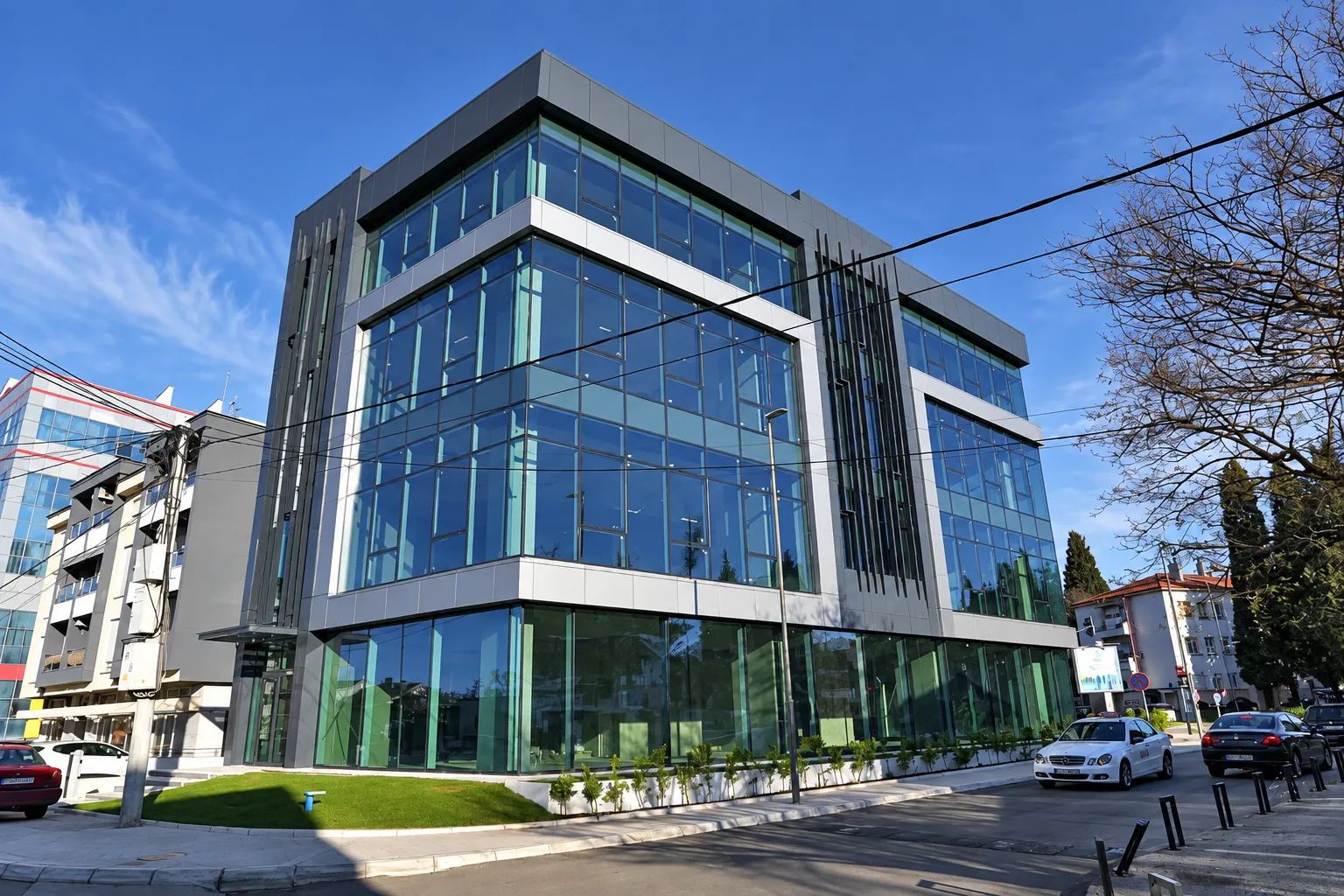 View of a modern commercial building with a glass facade and surrounding street.