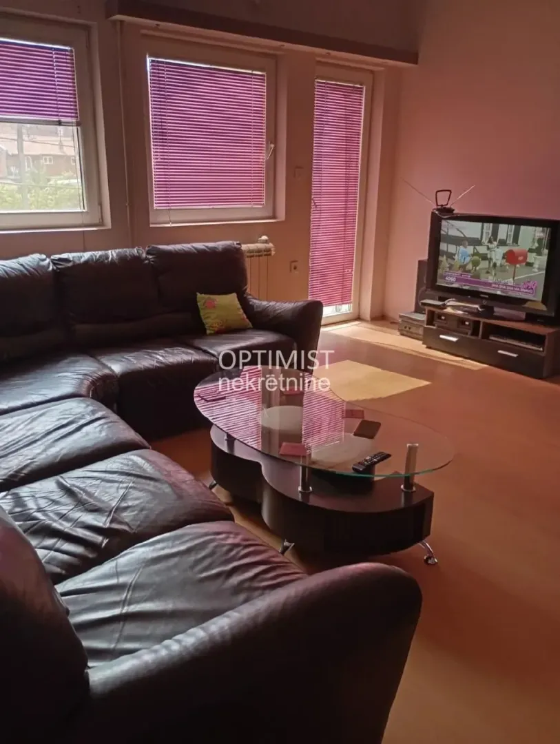 Living room with a leather sofa set and a television.