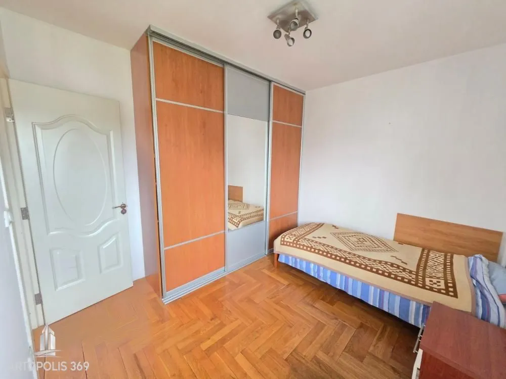 Spavaća soba sa krevetom i velikim ugradnim garderoberom.
