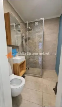 Modern bathroom with a shower enclosure, washbasin, and toilet. - image 8
