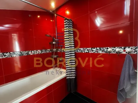 Kupatilo sa crvenim zidnim pločicama i kadom. - image 2