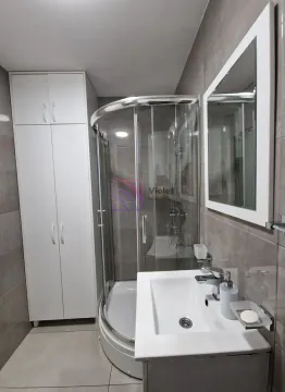 Moderne kupatilo sa tuš kabinom, umivaonikom i bijelim ormarićem. - image 11