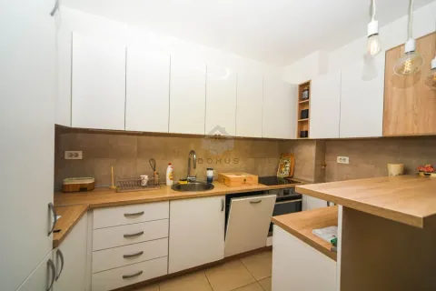 Moderna kuhinja sa bijelim elementima i drvenim radnim površinama. - image 5