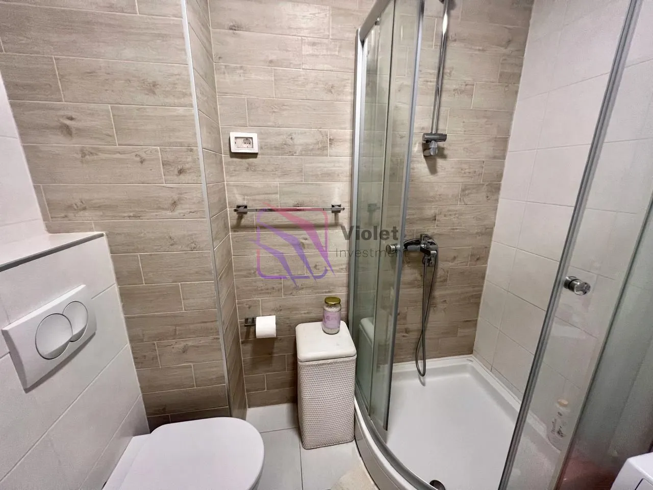 Smaller bathroom with a shower cabin and a built-in toilet.