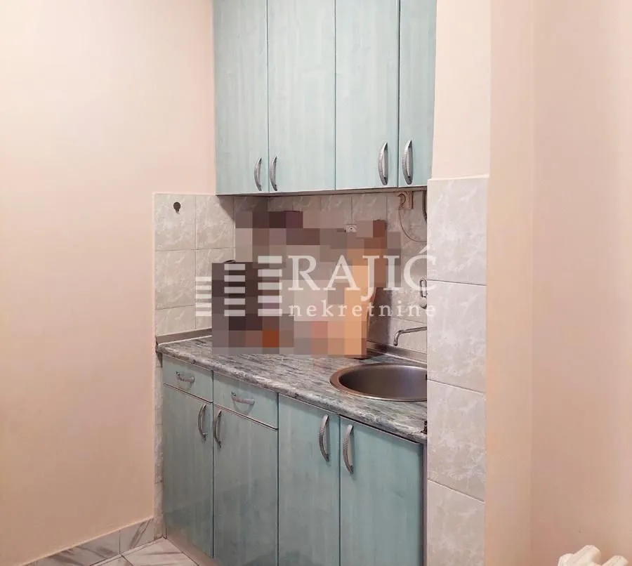 Small kitchen with light cabinets and a sink.