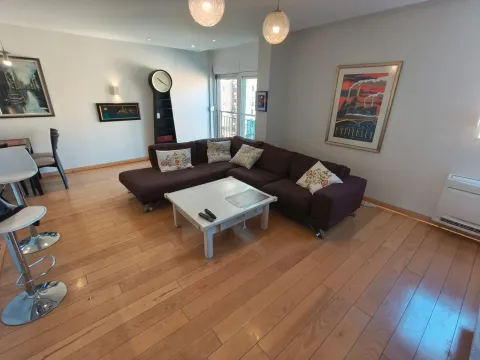 Spacious living room with a sectional sofa, wooden flooring, and a dining area. - image 12