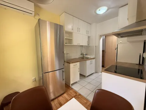 Small kitchen with white cabinets, stainless steel refrigerator and stove. - image 4