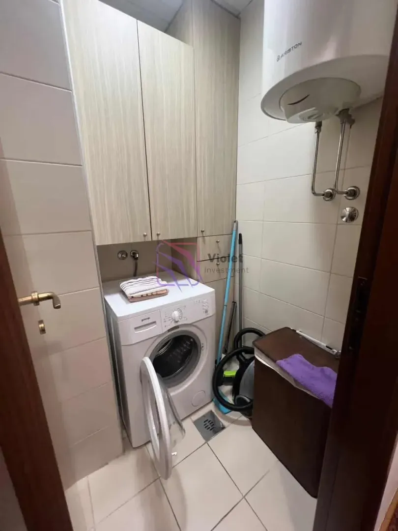Bathroom with a washing machine, built-in cabinets, and a water heater.