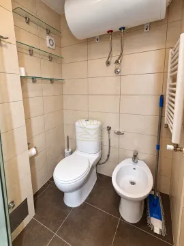 Compact bathroom with a toilet, bidet, and water heater. - image 15