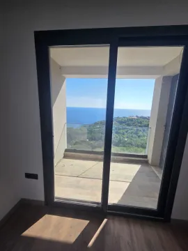 Pogled kroz balkonska vrata na terasu i more. - image 12