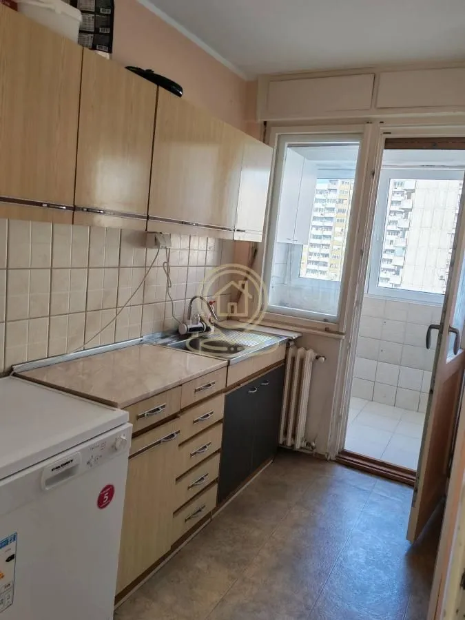 Smaller kitchen with wooden cabinets and access to the terrace.