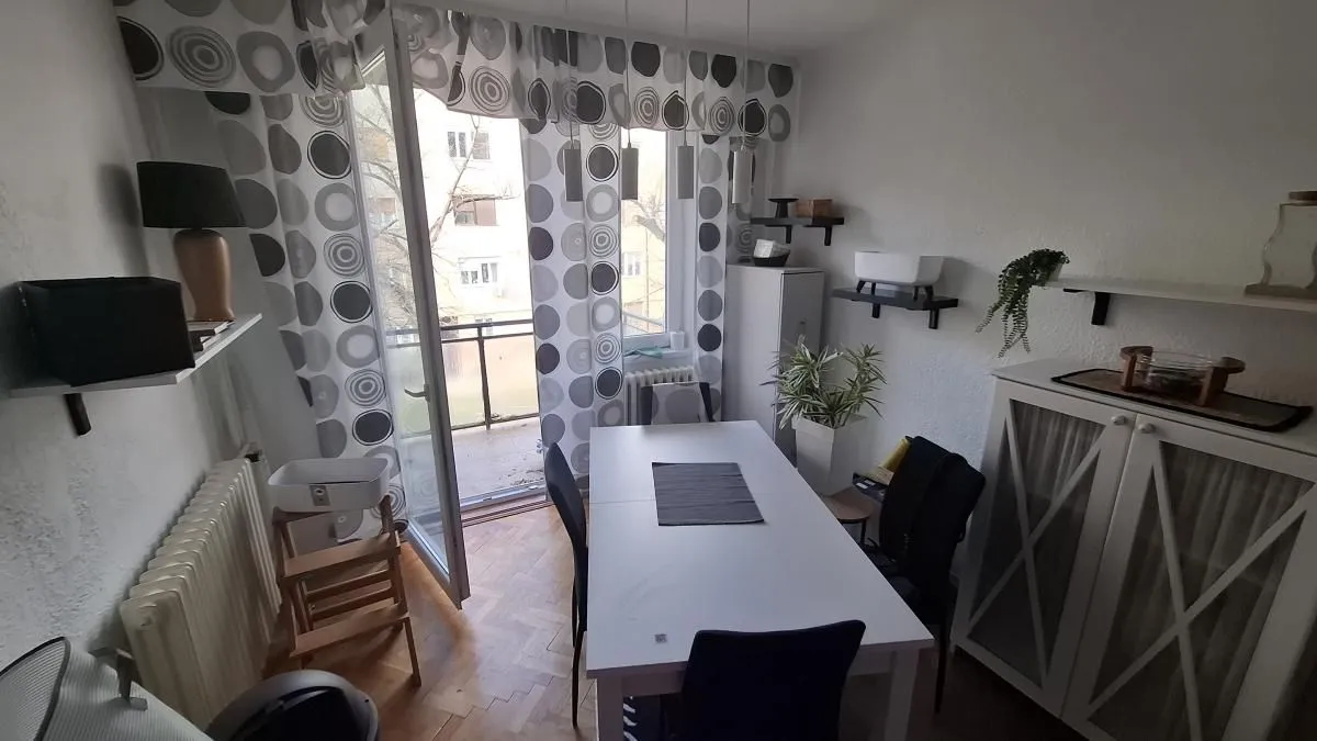 Trpezarija sa trpezarijskim stolom i izlazom na terasu.