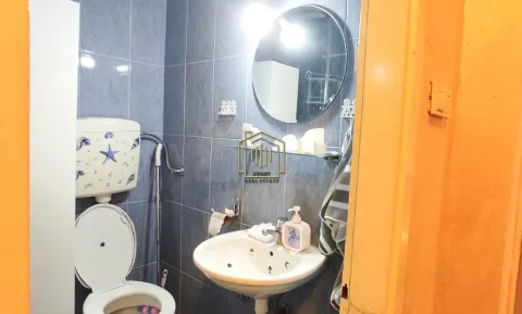 Smaller bathroom with blue tiles, washbasin, and toilet. - image 7