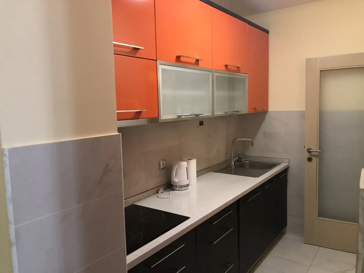 Kitchen with orange upper cabinets.